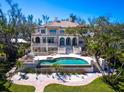 Beautiful outdoor living area with a large pool, patio, and lush landscaping, perfect for entertaining and relaxation at 1216 N Casey Key Rd, Osprey, FL 34229