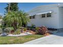 Charming detail shot of the home's exterior with lush landscaping and a mature palm tree at 1416 41St E Ave, Ellenton, FL 34222