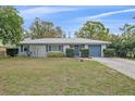 Charming one-story home boasts a well-manicured front lawn, complemented by mature landscaping and a gray metal roof at 1507 30Th W St, Bradenton, FL 34205