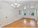 Bright living room with wood floors, white walls and trim, and a modern light fixture at 1507 30Th W St, Bradenton, FL 34205