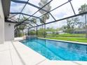 Gorgeous screened-in pool with clear blue water, and a serene backyard view with palm trees at 1575 Eastbrook Dr, Sarasota, FL 34231