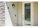 Detailed close-up of the front door with decorative glass, stone surround and modern hardware at 18117 Gawthrop Dr # 101, Lakewood Ranch, FL 34211