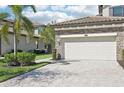 A large two car garage with a beautiful stone driveway and manicured lawn at 18117 Gawthrop Dr # 101, Lakewood Ranch, FL 34211