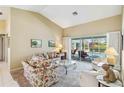 Living room with neutral tones, plush seating, and sliding doors to a screened lanai at 1878 Killdeer Ct, Venice, FL 34293