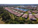 Panoramic aerial view of the neighborhood featuring ponds, landscaping, and tile roofs at 20186 Benissimo Dr, Venice, FL 34293