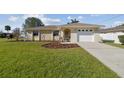 Charming single-story home featuring a manicured lawn, stone accents and an attached two car garage at 2412 15Th W St, Palmetto, FL 34221