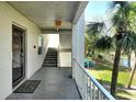 Hallway showing a condo doorway, railings, stairs and a glimpse of the water and lawn with palm trees at 3108 Lake Bayshore Dr # 211, Bradenton, FL 34205
