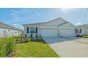 Charming paired home showcasing a manicured lawn, dual garage, and covered entryway at 427 157Th E Ct, Bradenton, FL 34212