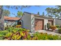 A one-car garage with brown door and vibrant landscaping offers curb appeal at 4423 Park Lake N Ter, Bradenton, FL 34209