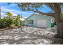 Beautifully landscaped home with a front lawn, modern pavers, and a white garage door at 511 68Th St, Holmes Beach, FL 34217