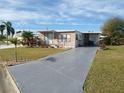 A well maintained single-story home with a long driveway and lush green lawn at 5235 Cherry Hill Ave, Sarasota, FL 34234