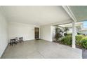 Open carport featuring concrete floors, neutral wall, and black door at 534 Sutton Pl, Longboat Key, FL 34228