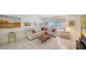 Comfortable living room with white sofa, tile floors, and a bright window at 534 Sutton Pl, Longboat Key, FL 34228