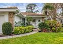 Inviting home featuring a landscaped front entrance, brick accents, and a decorative front door at 5614 Garden Lakes Dr, Bradenton, FL 34203