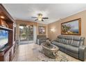 Cozy living room features tile flooring, comfortable seating, and a sliding glass door to the outdoors at 5700 Bentgrass Dr # 209, Sarasota, FL 34235