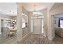 Elegant entryway with decorative molding, chandelier, and view into the living spaces at 6511 Turners Gap Rd, Bradenton, FL 34203