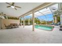 Relaxing screened-in pool area with spa, outdoor dining, lounge chairs, and a ceiling fan at 7604 49Th E Ave, Bradenton, FL 34203