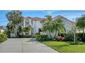 Beautiful home with well-maintained landscaping, mature palms, and a spacious circular driveway at 8025 Via Fiore, Sarasota, FL 34238