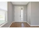 Bright foyer with a large white front door, light-gray walls, and wood-look floors at 8262 Velda Trl, Sarasota, FL 34241
