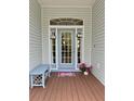 Charming front porch with a decorative blue door, welcome mat, and bench for seating at 1160 Mill Creek Rd, Bradenton, FL 34212