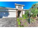 Home with stone accents, well-manicured lawn and garden, and a two-car garage at 13228 Saw Palm Creek Trl, Lakewood Ranch, FL 34211