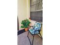 Relaxing front porch sitting area with a cozy chair and vibrant plant accents at 1412 56Th W St # 1412, Bradenton, FL 34209