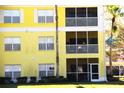 Close-up view of the exterior of the yellow condo building featuring screened lanais at 2060 Willow Hammock Cir # 201, Punta Gorda, FL 33983