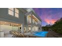 Luxury backyard featuring a pool, outdoor lounge, dining area, and bar, all under a beautiful wood-paneled ceiling at 215 83Rd St, Holmes Beach, FL 34217