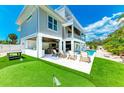 Backyard oasis featuring a putting green, outdoor kitchen, and a pool with sun loungers, perfect for entertaining at 215 83Rd St, Holmes Beach, FL 34217