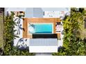 Aerial view of a backyard oasis with a sparkling pool, wooden deck, and tropical landscaping at 2308 Tulip St, Sarasota, FL 34239