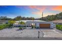Modern home with a white exterior, rock garden, stylish front door, and a two car garage at 2308 Tulip St, Sarasota, FL 34239