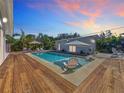 Inviting backyard pool with lounge chairs, umbrellas, and tropical foliage at 2308 Tulip St, Sarasota, FL 34239
