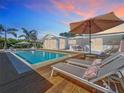 Inviting backyard pool area with lounge chairs, patio umbrella, and wood decking at 2308 Tulip St, Sarasota, FL 34239