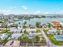 Scenic aerial view of a coastal neighborhood with waterfront homes, a vibrant cityscape, and blue waterways at 256 144Th Ave, Madeira Beach, FL 33708
