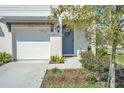 Close-up of a front entrance with a blue door and a white garage door on the side at 2718 Chestnut Creek Pl, Brandon, FL 33510