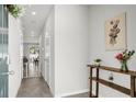 Bright hallway featuring neutral walls, tile floors, and a decorative table with flowers and botanicals at 2718 Chestnut Creek Pl, Brandon, FL 33510