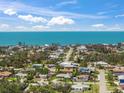 Stunning aerial view of coastal neighborhood homes with beautiful blue ocean in the background on sunny day at 317 Gulf Dr, Venice, FL 34285
