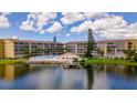 Beautiful aerial view of condos with pool, lush landscaping, and lake at 3525 Lake Bayshore Dr # 103J, Bradenton, FL 34205