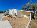 This home has a white stucco exterior, brick accents, and a small covered carport with room for a chair at 4 Braden Castle Dr, Bradenton, FL 34208