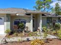 Close-up of home's front entrance, showcasing landscaped garden and a covered porch at 4627 Breezy Pines Blvd, Sarasota, FL 34232