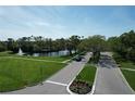 Aerial view of the community entrance, showcasing lush landscaping, a scenic pond with a fountain, and well-maintained grounds at 5211 Mahogany Run # 113, Sarasota, FL 34241