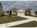 Beige single story home with a 2 car garage, stone accents and well maintained front yard at 5838 Elegant Orchid Way, Sarasota, FL 34232