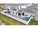 Rear exterior elevation featuring a private pool, patio, and a covered outdoor lounge area at 6027 White Mangrove Ln, Bradenton, FL 34210