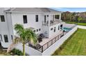 Rear exterior elevation with an upper balcony, a ground-level patio, and a private swimming pool at 6027 White Mangrove Ln, Bradenton, FL 34210