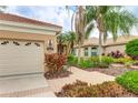 Lovely home exterior with a paver walkway, lush tropical landscaping, and an attached garage at 6103 Aviary Ct, Bradenton, FL 34203