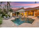 Gorgeous pool and patio with lounge chairs and outdoor dining at dusk at 612 Weston Pointe Ct, Longboat Key, FL 34228