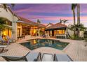 Inviting backyard pool and patio area perfect for outdoor entertaining at twilight at 612 Weston Pointe Ct, Longboat Key, FL 34228