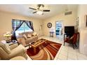 Inviting living room featuring tile flooring, a ceiling fan, and a cozy seating arrangement at 6924 Tuxedo St, Englewood, FL 34224