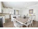 Open-concept dining area featuring modern lighting, a large dining table, and stylish chairs at 7547 Campus Cv, Sarasota, FL 34243