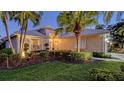 Inviting home with a well-manicured lawn, lush landscaping, and accent lighting to show the architecture at night at 7903 Hampton Ct, University Park, FL 34201